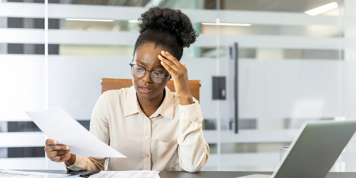 Entrepreneur managing bookkeeping and business finances independently using a laptop and financial documents